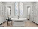 Luxurious bathroom featuring a standalone tub, large window, and elegant white cabinetry at 4874 Kettle River Pt, Suwanee, GA 30024