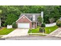 Lovely front exterior showcasing a well-kept lawn, attached garage, and brick facade at 320 Cloverwood Drive, Fayetteville, GA 30215