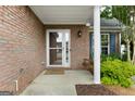 Close-up of a cozy brick porch with a swing, perfect for enjoying the outdoors at 320 Cloverwood Drive, Fayetteville, GA 30215