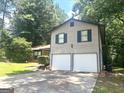 Two-story home featuring a two-car garage, brick accents, and lush green lawn at 4263 Southvale Dr, Decatur, GA 30034