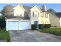 Two-story home with a two-car garage, lawn, and tidy landscaping at 2561 Lancewood Ln, Lithonia, GA 30058
