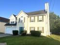 Two-story home with a two-car garage, lawn, and tidy landscaping at 2561 Lancewood Ln, Lithonia, GA 30058