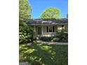 Charming home featuring a cozy front porch with white railing and steps, set amidst lush greenery at 140 Dixie Ln, Covington, GA 30014