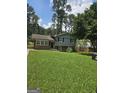 Charming home with a well-maintained lawn and a mix of brick and siding, nestled among mature trees, under a sunny sky at 993 Roosevelt Se Dr, Atlanta, GA 30354