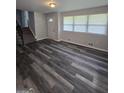 Open living space with modern wood floors, leading to a staircase with carpeted steps and ample natural light at 993 Roosevelt Se Dr, Atlanta, GA 30354