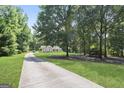 Long driveway leading to a cozy home surrounded by mature trees, offering privacy and a sense of tranquility at 8340 Highway 54, Sharpsburg, GA 30277