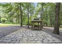 Picturesque gazebo with stone flooring, nestled among towering trees, providing a serene outdoor retreat at 8340 Highway 54, Sharpsburg, GA 30277