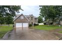 Inviting two-story brick home featuring a two-car garage and a well-maintained lawn at 705 Mustang Ct, Hampton, GA 30228