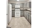 Functional kitchen with grey cabinets, white appliances, and tile flooring at 755 Magnolia Gardens Walk, Mcdonough, GA 30253