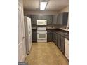 Functional kitchen with gray cabinetry, modern white appliances, and vinyl flooring at 755 Magnolia Gardens Walk, Mcdonough, GA 30253