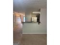 Open-concept living space featuring a breakfast bar and seamless flow to hallway and kitchen at 755 Magnolia Gardens Walk, Mcdonough, GA 30253