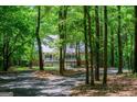 Secluded home with a metal roof and inviting front porch, nestled among mature trees and lush foliage at 301 East Highway 5, Roopville, GA 30170