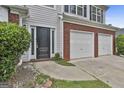 View of the home's front door and two-car garage with painted white doors at 1255 Silverstone Trl, Jonesboro, GA 30238