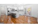Bright, open kitchen with stainless steel appliances, white cabinets, hardwood floors, and an island with seating at 3859 N Camp Creek Sw Pkwy, Atlanta, GA 30331