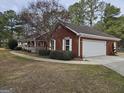 Lovely red brick home with white trim, an attached garage, and a well-manicured lawn at 164 Turner Creek Dr, Hampton, GA 30228
