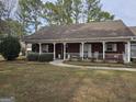 Inviting red brick home with a covered porch, white railings, and decorative outdoor lighting at 164 Turner Creek Dr, Hampton, GA 30228