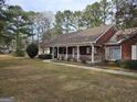 A charming brick home with a covered porch and neatly kept front lawn showcasing curb appeal at 164 Turner Creek Dr, Hampton, GA 30228
