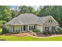 Attractive single-story home with stone accents, lush lawn and mature landscaping at 320 Silverbell Ln, Sharpsburg, GA 30277