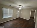 Inviting living room with hardwood floors, neutral paint, a ceiling fan, and ample natural light at 9107 Morris Sw Dr, Covington, GA 30014