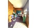 A room with wood paneled walls, with shelves and vintage furniture at 301 Wedowee St, Bowdon, GA 30108