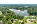 An aerial view shows home on a large lot with water views and a lush tree canopy at 1919 Lake Lucerne Sw Way, Lilburn, GA 30047