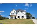 Newly constructed two-story home with white siding, dark roof, front porch, and manicured lawn on a sunny day at 45 Duffy Dr., Mcdonough, GA 30253
