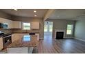 Open-concept kitchen with granite countertops, white cabinets, stainless steel appliances, and views to the living room at 45 Duffy Dr., Mcdonough, GA 30253