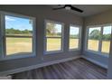 Bright sunroom with large windows offering expansive views of the surrounding landscape and a ceiling fan at 45 Duffy Dr., Mcdonough, GA 30253