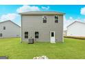 Exterior view of a home's backyard with a well-maintained lawn and white door at 102 Avondale Blvd, Conyers, GA 30013