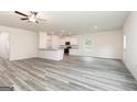 Spacious open-concept living area featuring hard surface floors, white walls, and an adjoining kitchen at 282 Limestone Circle, Conyers, GA 30013