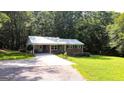 Quaint brick home with a carport and well-maintained front yard and shady trees at 1833 S Highway 92, Fayetteville, GA 30215