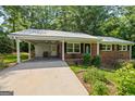 Inviting brick home featuring a carport, covered entry, and manicured landscaping at 1833 S Highway 92, Fayetteville, GA 30215