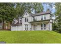 Charming two-story home with a covered front porch and attached two-car garage surrounded by mature trees at 539 Riverbirch Trce, Stone Mountain, GA 30087