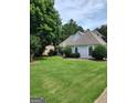 Side view of home featuring a meticulously manicured lawn and manicured greenery at 2911 Chesterfield Se Way, Conyers, GA 30013