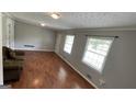 Bright living room featuring hardwood floors, neutral walls, and large windows at 8436 Magnolia Dr, Jonesboro, GA 30238