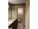 Traditional bathroom featuring granite counters, dark cabinets and decorative wallpaper at 177 Northwind Sw Ct, Lilburn, GA 30047