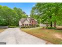 View of a two-story brick home with a long driveway and mature trees at 10044 Point View Dr, Jonesboro, GA 30238