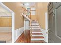 Inviting foyer with wood floors, staircase, and white wainscoting at 10044 Point View Dr, Jonesboro, GA 30238
