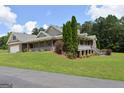 Spacious home with a covered porch, brick facade, and mature trees in a serene setting at 195 Twin Oaks Dr, Hampton, GA 30228