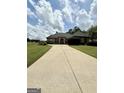 Spacious home boasts a long concrete driveway and lush lawn, creating a welcoming curb appeal at 6409 Caledon Ct, Locust Grove, GA 30248