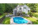 Beautiful backyard featuring a sparkling in-ground pool, a deck, and lush greenery at 551 Lees Mill Rd, Fayetteville, GA 30214
