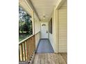 Covered front porch with wood flooring and a wooden railing leads to the white front door at 4688 Brice Dr, Union City, GA 30291
