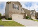 Two-story home showcasing a two-car garage, stone detailing, and well-maintained landscaping at 529 Dasheill Ln, Atlanta, GA 30349