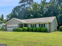 Charming single story home with stone accents, lush green lawn, and manicured shrubbery showing inviting curb appeal at 2866 Rosecommons Dr, Hampton, GA 30228