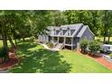 Inviting gray home boasts lush landscaping, mature trees, and a spacious driveway, perfect for outdoor enjoyment at 152 Bear Creek Rd, Moreland, GA 30259