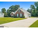 Brick home with an attached garage and long concrete driveway at 1032 Shumard Ln, Mcdonough, GA 30252