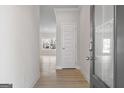 Welcoming entryway with light wood floors, white walls, and modern digital lock at 4464 Eastbrook Pl # 56B, Snellville, GA 30039