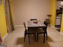 Dining room area with a wooden table and chairs, plus neutral colors and earth tone tiled floors at 2498 Robinhood Dr, Ellenwood, GA 30294