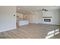 Open-concept living area with modern fireplace, white trim, and direct access to the kitchen at 4454 Eastbrook Pl # 57B, Snellville, GA 30039