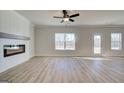 Spacious living room with a fireplace, wood flooring, large windows, and a ceiling fan at 4434 Eastbrook Pl # 59A, Snellville, GA 30039